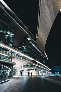 three people walking near building during nighttime thumbnail