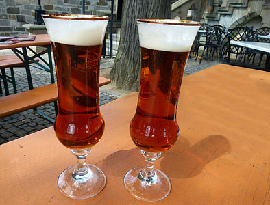 two clear glass footed cups with red liquid on table thumbnail