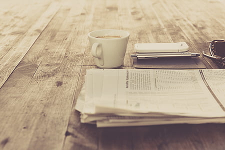 gray newspaper beside white coffee cup thumbnail