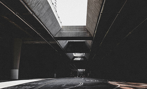 grayscale photo of empty concrete road with concrete long bridge thumbnail