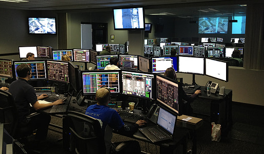 person wearing blue long-sleeved shirt while using desktop computer set thumbnail
