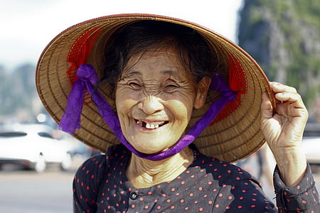 woman wearing brown wicker hat showing smile thumbnail