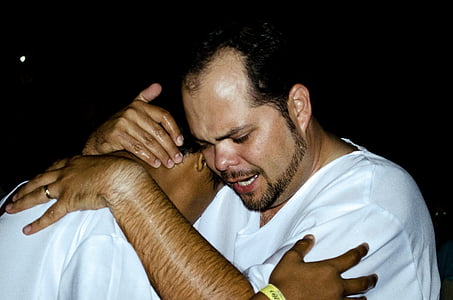 man hugging another man inside deemed room thumbnail