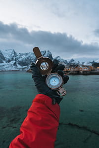 Person Wearing Black Leather Gloves Holding Brass-colored Compass thumbnail