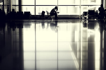 man sitting on chair beside glass window thumbnail