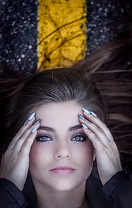 woman holding forehead closeup photography thumbnail