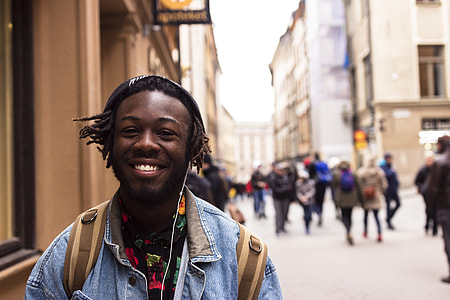 man standing near people and buildings thumbnail