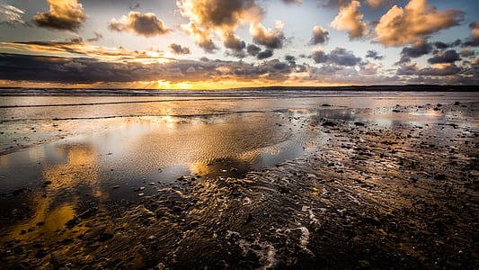 calm body of water under blue cloudy sky during daytime thumbnail