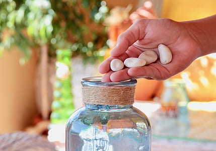 four white stones and clear glass jar thumbnail