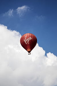 red Virgin hot air balloon flying over blue and white sky thumbnail