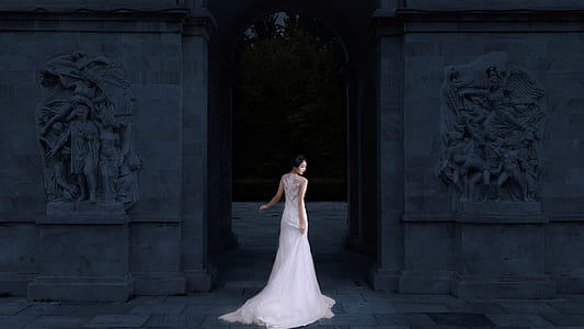 woman standing holding her gown in front of building thumbnail
