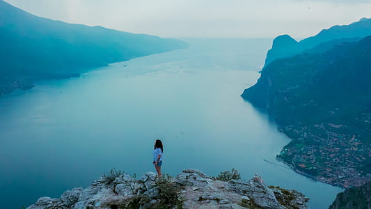 Woman Standing on Mountain during Dayttime thumbnail