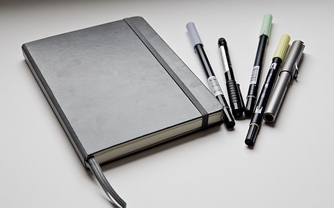 black leather notebook and five pens thumbnail