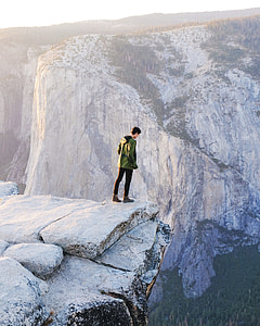 man standing on cliff on rock thumbnail