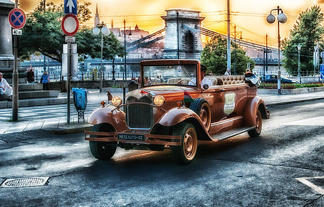 brown classic convertible sedan cruising on the road during daytime thumbnail