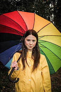 girl holding multicolored umbrella outdoors thumbnail