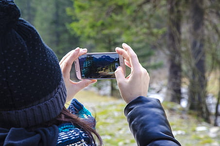 person holding gold Samsung Android smartphone taking photo of trees thumbnail