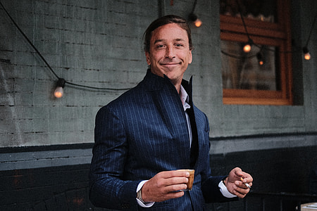 man standing front of wall while smiling thumbnail