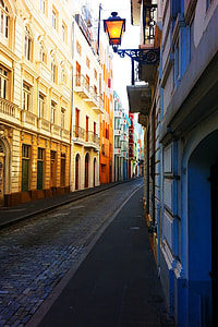grey brick pavement in between yellow and blue high-rise buildings thumbnail
