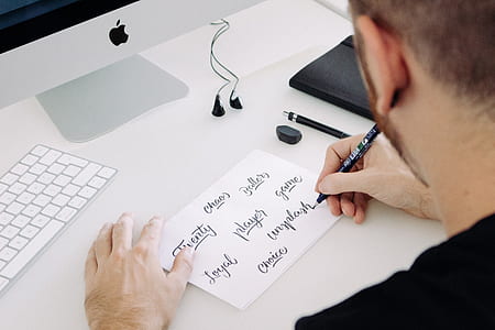 person holding black pen while writing on paper thumbnail