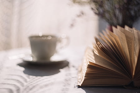 opened book beside teacup on saucer thumbnail