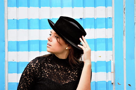woman holding black hat thumbnail