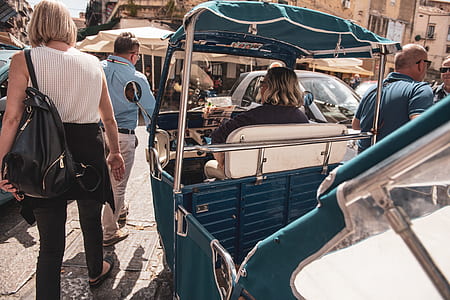 people walking beside person riding auto-rickshaw at daytime thumbnail