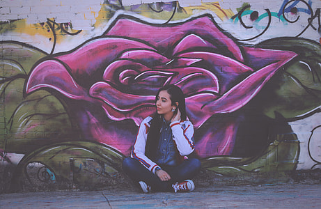 woman sitting in front of purple flower wall graffiti thumbnail