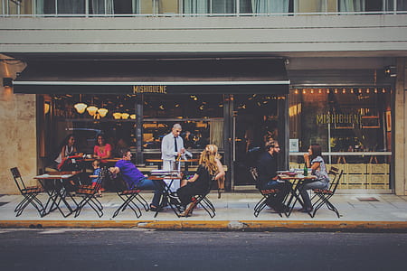 photo of people sitting on dining table beside restaurant thumbnail