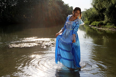 woman in blue dress standing on body of water thumbnail