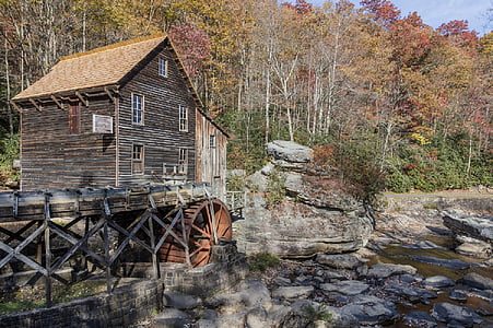brown and black wooden house near river and forest thumbnail