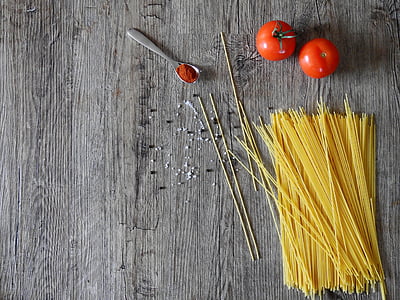 uncooked pasta and two red tomato fruits on grey wooden surface thumbnail