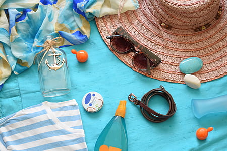 black sunglasses beside assorted-color gemstones and sun hat thumbnail