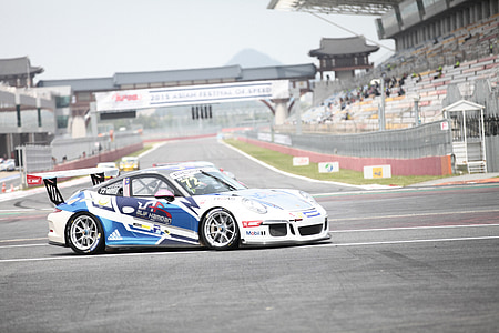 blue and white Porsche race car on track thumbnail