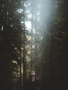 woman wearing black top near trees standing during daytime thumbnail