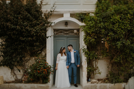 newly wed couple in front of closed door thumbnail