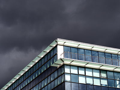 glass windowed building under gray sky during daytime thumbnail