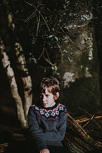 child sitting on tree log thumbnail