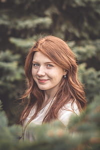 selective focus photo of woman standing in front of green leafed tree thumbnail