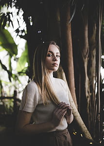 woman touching hair while standing thumbnail