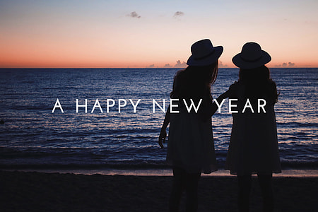 A happy new year text with background of woman walking on the beach at sunset view thumbnail