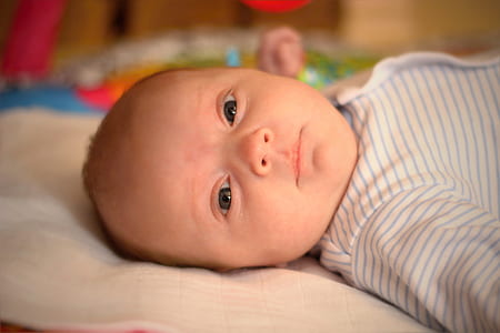 baby laying on white cloth thumbnail