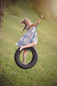 woman wearing blue and gray dress on rubber tire swing thumbnail