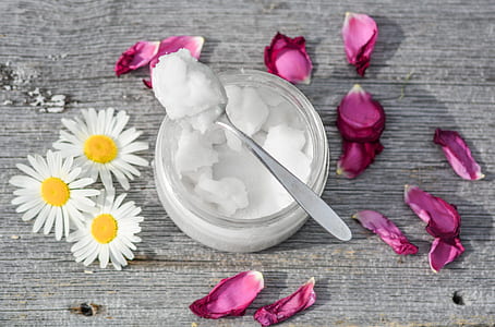 photo of stainless steel spoon with white substance in clear glass jars with petaled flowers thumbnail