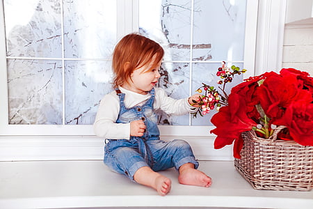 child wearing gray denim jumpsuit sitting on white table thumbnail