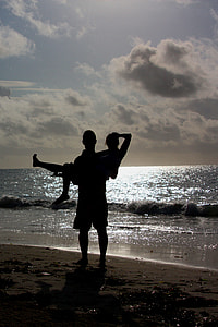 silhouette of man carrying woman near the seashore during sunset thumbnail
