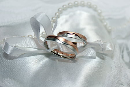 silver-colored wedding rings tied with ribbon thumbnail