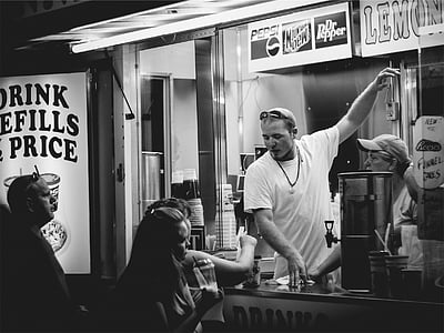 grayscale photo of man inside the food stall thumbnail