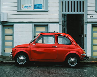 classic red 3-door hatchback parked on roadside thumbnail
