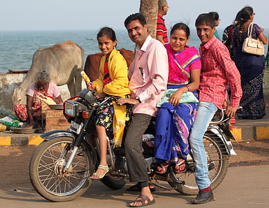 group of people riding motorcycle on road near body of water during daytime thumbnail